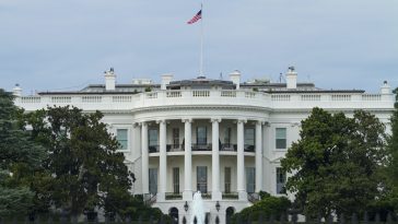 White Concrete Building With Flags on Top