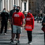 man in red crew neck t-shirt and black pants walking on street during daytime