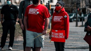 man in red crew neck t-shirt and black pants walking on street during daytime